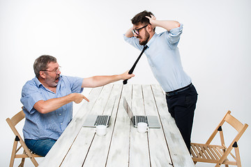 Image showing Business conflict. The two men expressing negativity while one man grabbing the necktie of her opponent