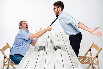 Image showing Business conflict. The two men expressing negativity while one man grabbing the necktie of her opponent