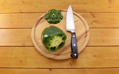 Image showing Green pepper sliced open with a knife on a chopping board