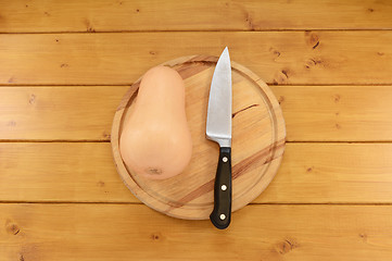 Image showing Butternut squash with a knife on a chopping board