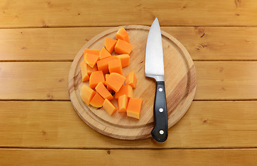 Image showing Chopped butternut squash with a knife on a chopping board 