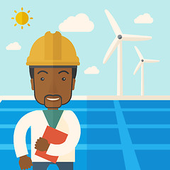 Image showing Black man in solar panel and windmills.