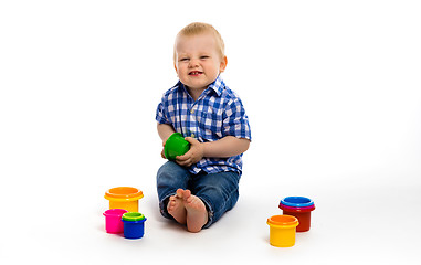 Image showing Happy baby in a plaid shirt with toys. studio