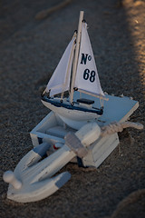 Image showing sailing boat and seashell in sand decoration closeup