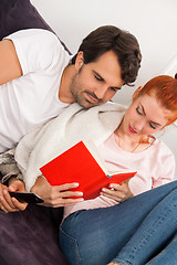 Image showing Sweet Couple Resting on Couch While Reading a Book