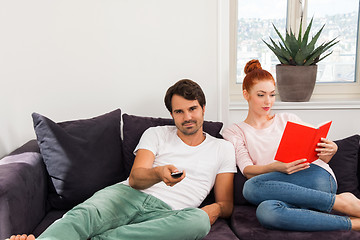 Image showing Sweet Couple Resting on Couch While Reading a Book