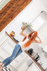 Image showing Happy Woman Using a Pineapple as Microphone