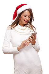 Image showing Pretty woman in a Santa hat reading an sms