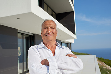 Image showing senior man in front of modern home