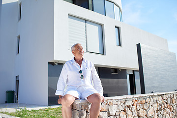 Image showing senior man in front of modern home