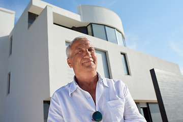 Image showing senior man in front of modern home