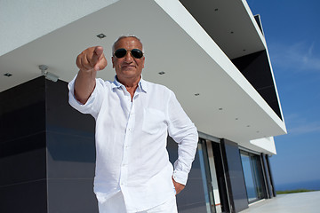 Image showing senior man in front of modern home