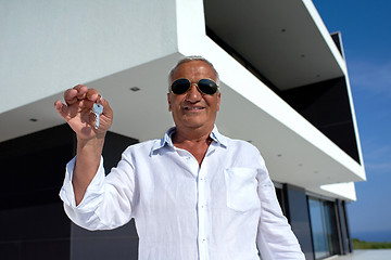 Image showing senior man in front of modern home