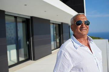 Image showing senior man in front of modern home