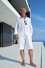 Image showing senior man in front of modern home