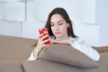 Image showing young woman using cellphone at home