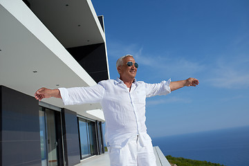 Image showing senior man in front of modern home