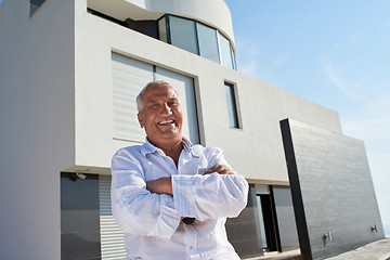 Image showing senior man in front of modern home