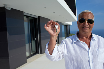 Image showing senior man in front of modern home