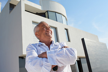 Image showing senior man in front of modern home