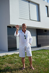 Image showing senior man in front of modern home