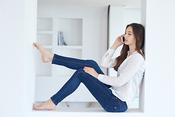 Image showing young woman using cellphone at home