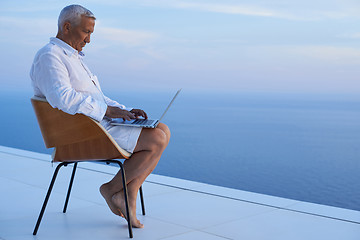 Image showing senior man working on laptop computer