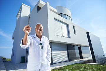 Image showing senior man in front of modern home