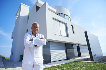 Image showing senior man in front of modern home