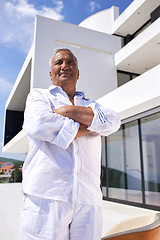 Image showing senior man in front of modern home