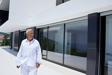 Image showing senior man in front of modern home