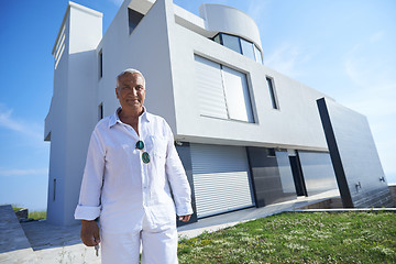 Image showing senior man in front of modern home