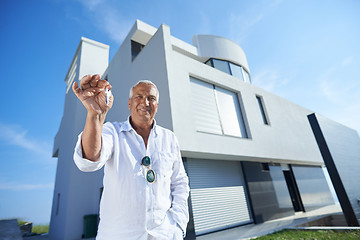 Image showing senior man in front of modern home