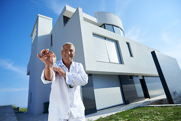 Image showing senior man in front of modern home