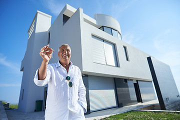 Image showing senior man in front of modern home