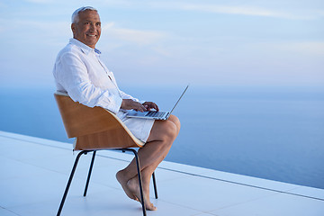 Image showing senior man working on laptop computer