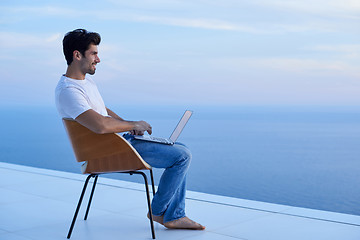 Image showing relaxed young man at home on balcony