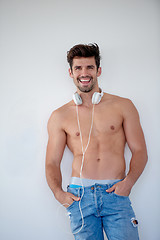 Image showing handsome young man listening music on headphones