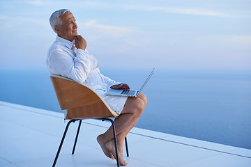 Image showing senior man working on laptop computer