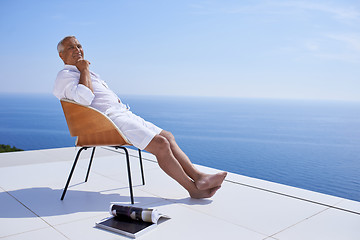 Image showing senior man in front of modern home