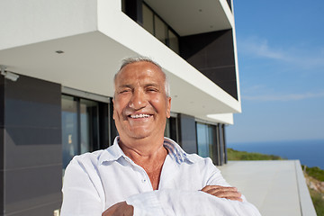 Image showing senior man in front of modern home