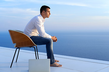 Image showing relaxed young man at home on balcony