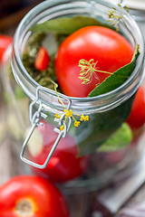 Image showing Fresh tomatoes and spices in a jar for canning.