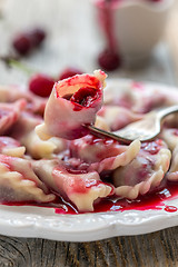 Image showing Dumplings with a cherry on a fork.