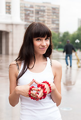 Image showing Young pretty woman walking on city after rain