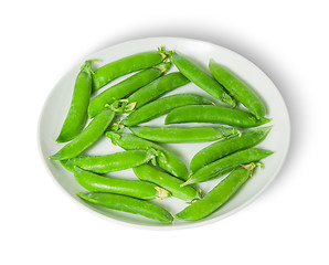 Image showing Several pods of peas on a white plate