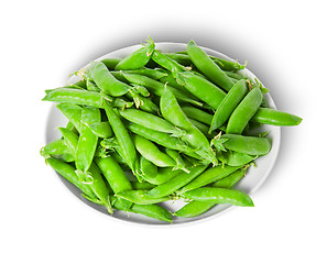 Image showing Small pile of green peas in pods on white plate