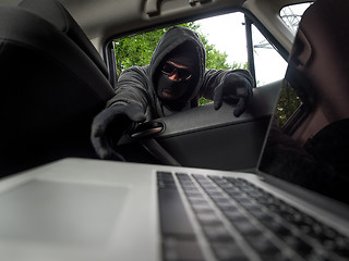 Image showing Crime concept - thief stealing laptop from the car. View from laptop