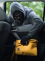 Image showing Transportation crime concept .Thief stealing bag from the car