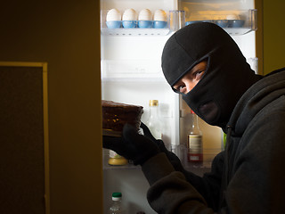 Image showing Thief. Man in black mask with a cake.